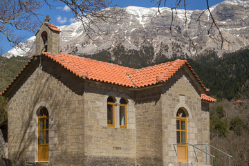 Fototapeta na wymiar Kipseli village st Panteleimon church view to the mountain Tzoumerka in winter