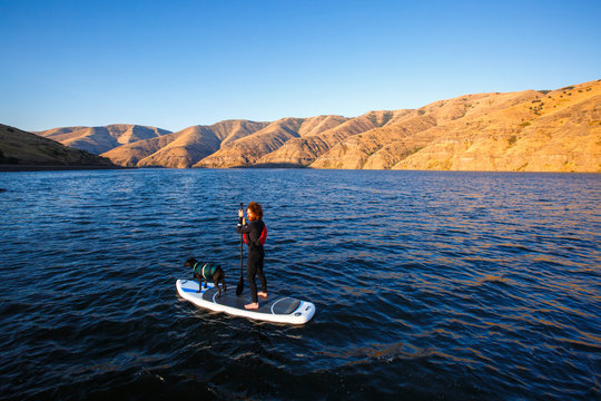 Nate Macconnel and Dora the black lab paddle out on the Snake River during an early morning summer SUP session in southeast Washington.
