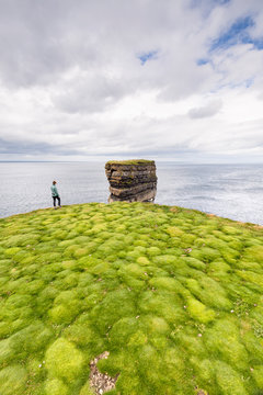 Downpatrick Head, Knockaun, Ballycastle, Mayo, Ireland: A person walking along the cliffs over the grass with its unique pattern.