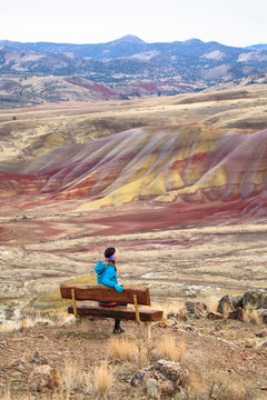 A woman takes in the views of along the 3/4 mile Carroll Rim Trail at the Painted Hills in the John Day Fossil Beds National Monument in eastern Oregon.