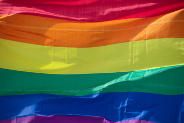 A LGBT gay pride rainbow flag being waved at a pride community celebration event