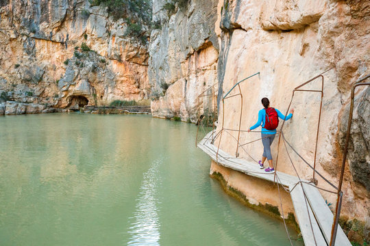 A woman walks by the teal water sof the Charco Azul near Chulilla, Spain.