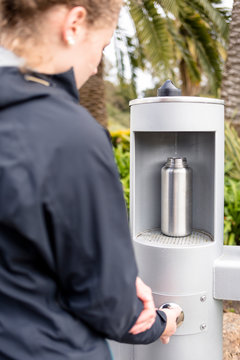 San Francisco, California, USA: A young woman refilling her water bottle(s) at a water dispenser at the Golden Gate Park.