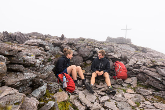 Carrantuohill (mountain), Coomcallee, Kerry, Ireland: Two hikers resting ontop of the highest mountain in Ireland.