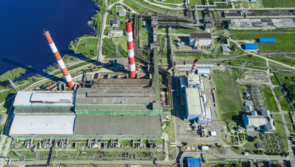 Industrial plant on the background of the lake. Thermal power plant and electricity. Technology and ecology. Photos from the drone.