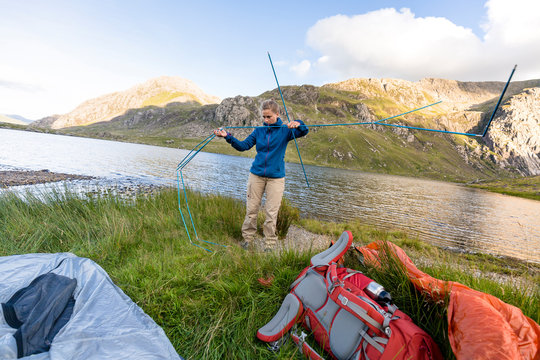 Snowdonia National Park, Bangor, Wales, United Kingdom: Two hikers setting up their tent right by the lake.