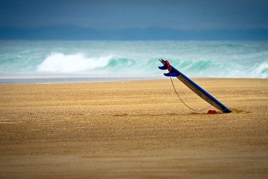 Surfboard stuck into the beach of Les Casernes, France.