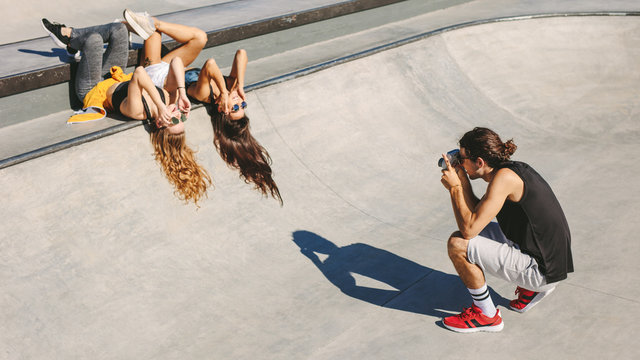 Photographer taking pictures of women at skate park