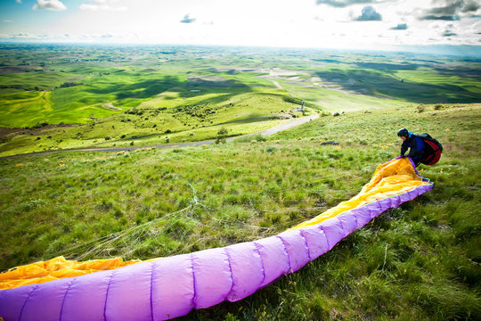 A man rolls out his chute while preparing to paraglide off Steptoe Butte in eastern Washington.