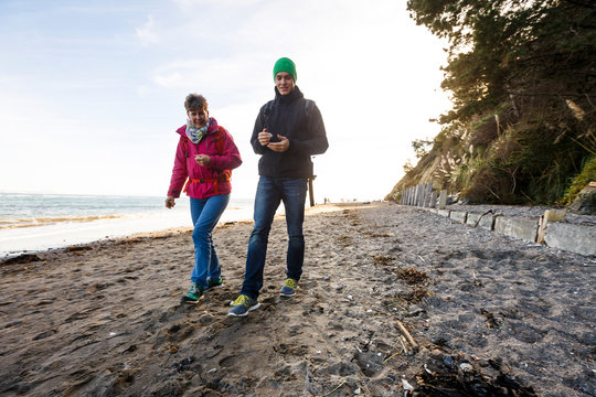 Bolinas Beach, California, USA: A mother and her son collecting rocks and shells at the beach.