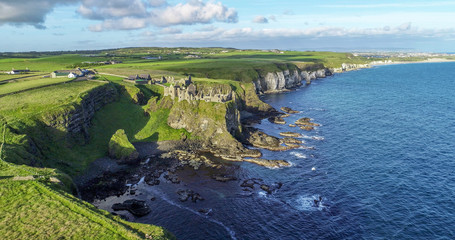 Ruins of medieval Dunluce Castle on a steep cliff near Bushmills. Northern coast of County Antrim,...