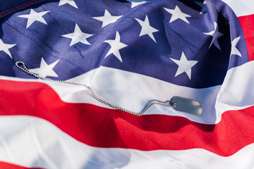 Silver badge on chain near American flag with stars and stripes