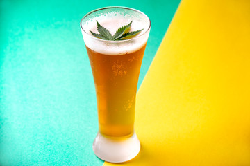 Detail of cold glass of beer with cannabis leaf