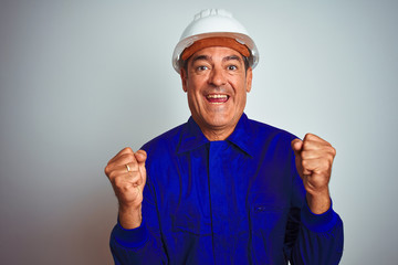 Handsome middle age worker man wearing uniform and helmet over isolated white background celebrating surprised and amazed for success with arms raised and open eyes. Winner concept.