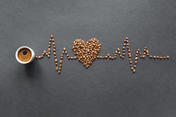 A cardiogram of coffee beans and a cup of coffee on a black background