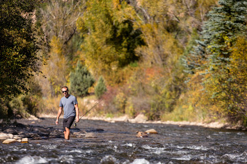 San Miguel River, near Telluride, Colorado, USA: A male fly fisher walking up the river.