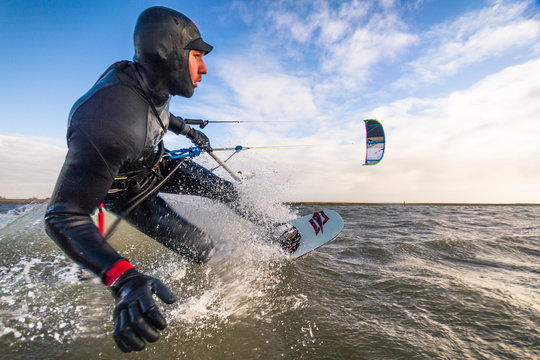 Kiteboarder shredding on the German Sea during a beautiful day in February in St. Peter Ording, Germany