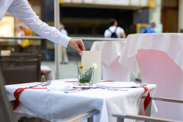 Closeup of a womans hand fixing a table for a nice dinner