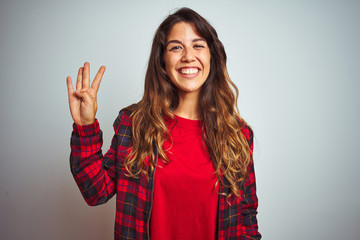 Young beautiful woman wearing red t-shirt and jacket standing over white isolated background showing and pointing up with fingers number four while smiling confident and happy.