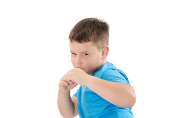 Close up Serious White Fighter Male Kid in Blue Clothing Posing with Closed Fists While Looking at the Camera. Isolated on White Background