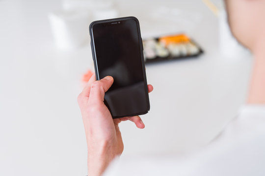 Close upf man using smartphone to orden take away asian food from delivery