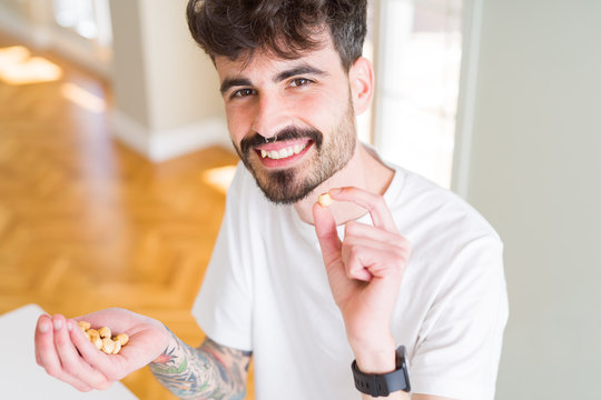 Young man eating hazelnuts, close up of hand with a bunch of healthy nuts
