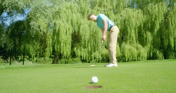 A golfer sinks a successful putt.