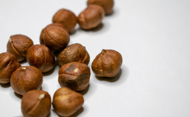 Several varieties of nuts are located on a white sheet of paper.