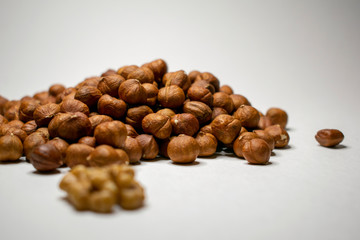 Several varieties of nuts are located on a white sheet of paper.