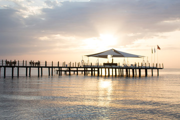 Fototapeta na wymiar Pier in the azure sea during the dawn.