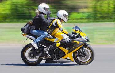 Active couple riding on the motorbike, slow motion, having fun in bikers tour, happy adventure concept on spring road