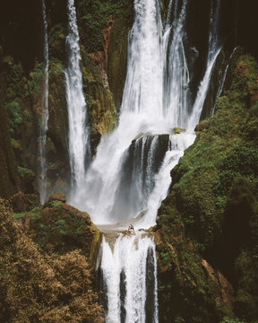 desert terrain with powerful majestic waterfall on green cliffs, Morocco