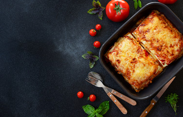 Homemade Italian Lasagna with Tomato Sauce and Chicken, Served with Tomatoes and Basil. Two...