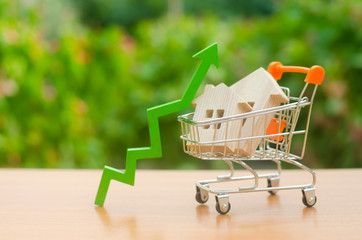 Two wooden houses in a trading cart and green arrow up. Increasing cost and liquidity of real...