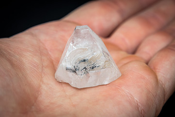 Holding a dob rough diamond formed by volcanic heat and pressure inside the earth