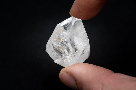 Holding a dob rough diamond formed by volcanic heat and pressure inside the earth