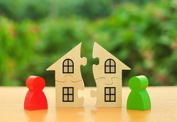 Two human figures divide the house among themselves. Divorce concept. Disputes over division...