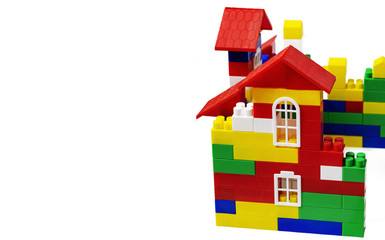 Multi-storey multi-colored house of toy plastic cubes. Close up. Copy space