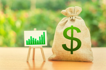 Money bag with dollar symbol and a stand with a green growth trend chart. Increase profits and wealth. growth of wages. Favorable conditions for business. Investment attraction. loans and subsidies - obrazy, fototapety, plakaty