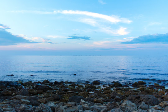 Beautiful blue sky and stone beach before sunset on the sea