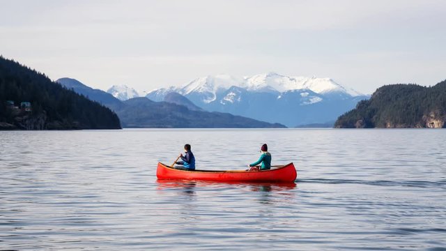 Cinemagraph of a Couple friends canoeing on a wooden canoe during a sunny day. Taken in Harrison Lake, East of Vancouver, British Columbia, Canada. Still Image Continuous Animation