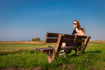 Naklejka na ściany i meble blonde girl sitting on a bench
