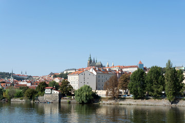 Panoramic view of Vltava river, Prague castle, and colorful rooftops of New Town on a bright summer day, in Prague, Czech Republic