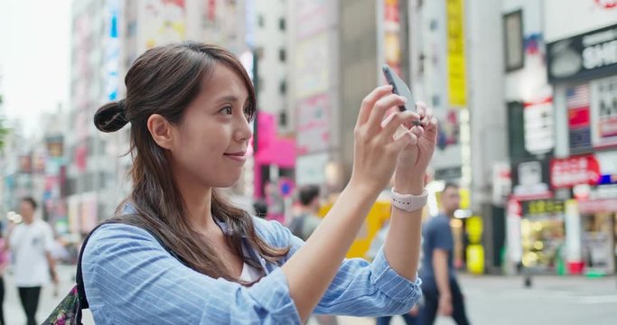 Backpacker woman visit Tokyo city, take photo on cellphone