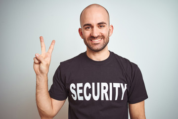 Young safeguard man wearing security uniform over isolated background showing and pointing up with...