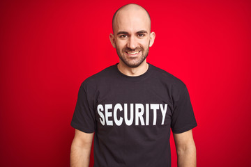 Young safeguard man wearing security uniform over red isolated background with a happy and cool...