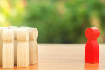 Red figurine of a man stands aside from the crowd of people. Asociality, sociopathy. Rejected from...