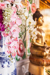 Flores y estatuilla de buda en un templo en asia