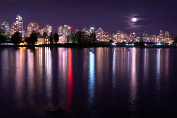 Fototapeta na wymiar Vancouver Skyline Night Coal Harbor. The Vancouver skyline reflects in Burrard Inlet at night. British Columbia, Canada.