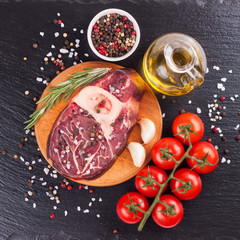 meat steak and cooking ingredients on black background